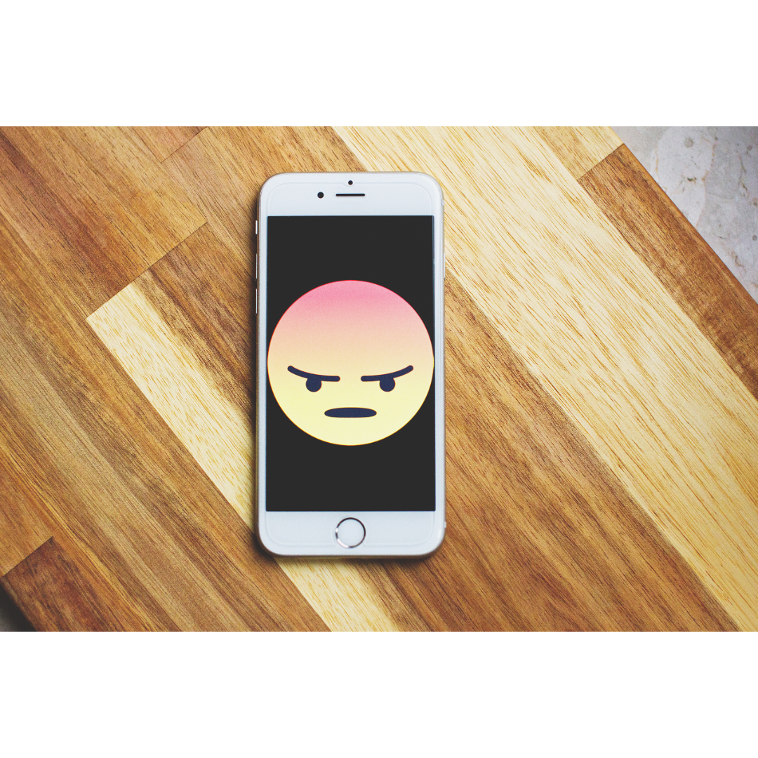 Mobile phone with a picture of a frustrated emoji.