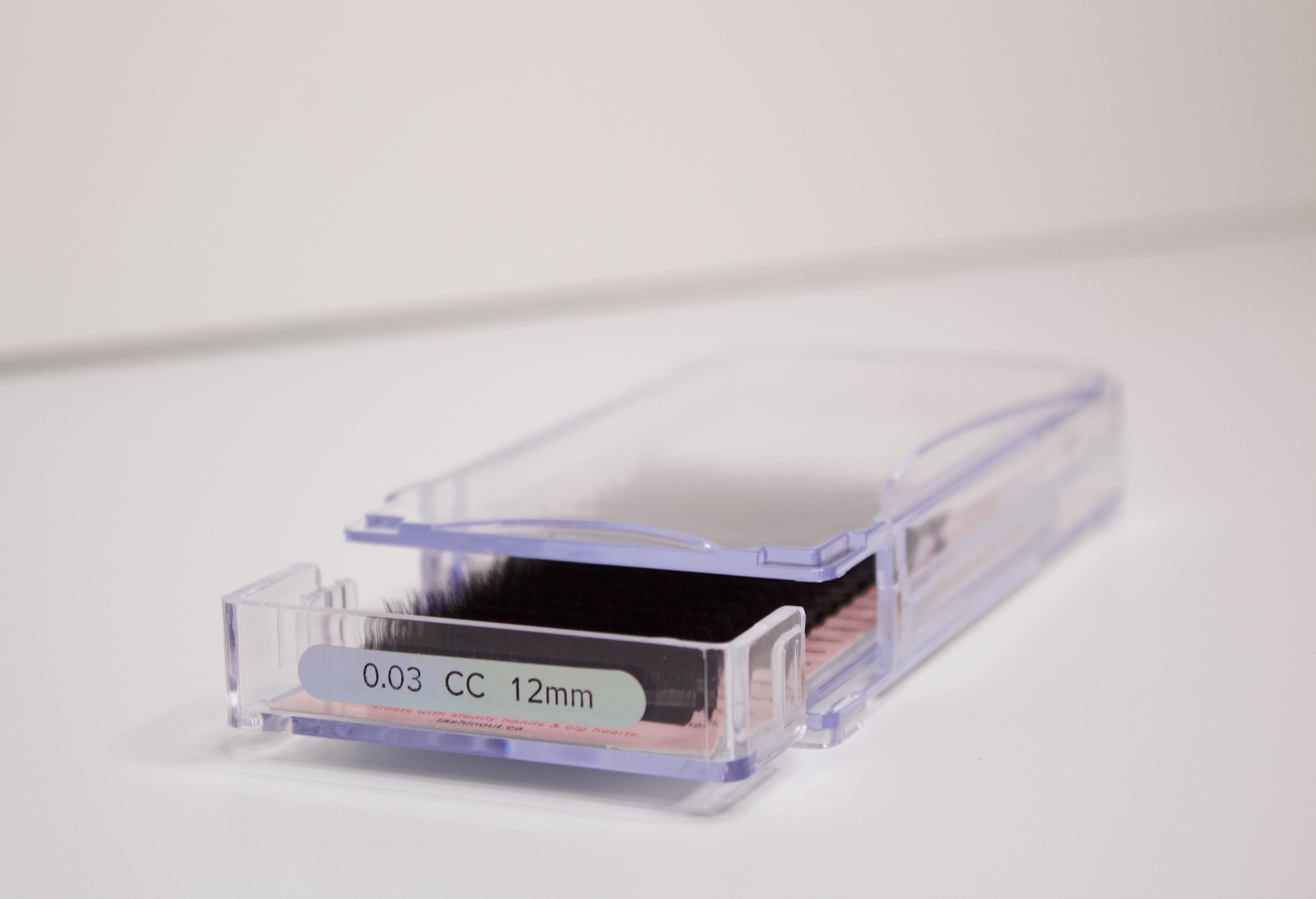 Volume lash extensions in a clear plastic tray. The tray says 0.03 CC 12 mm on the front.
