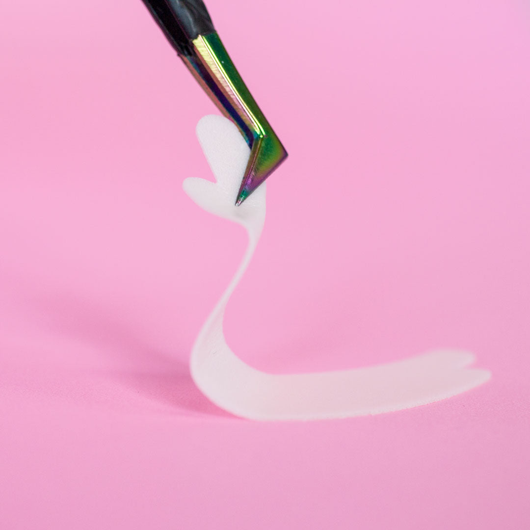 A pair of tweezers is holding a flexi foam eye pad
