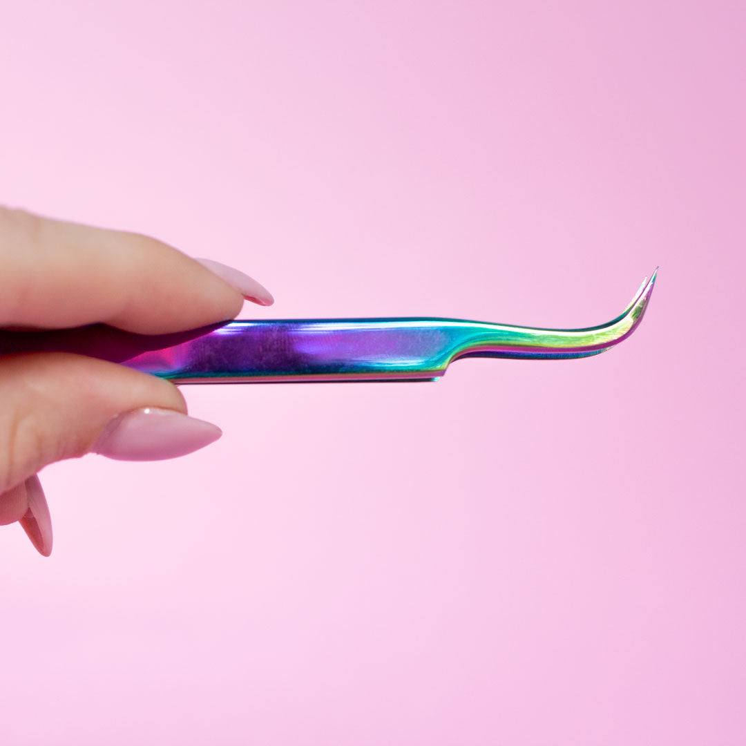 A hand holding the Vetus Curved Lash Tweezers facing upwards