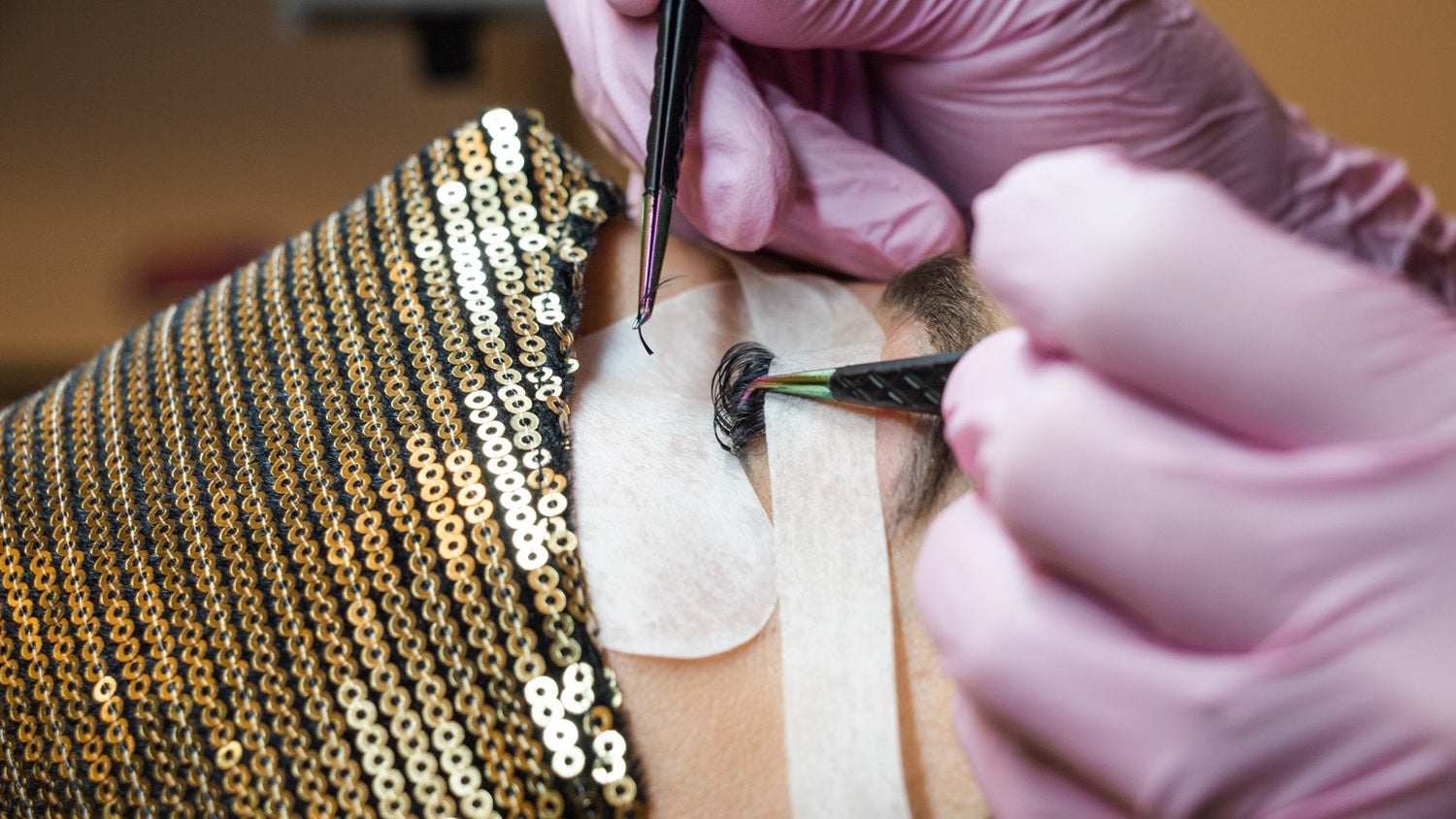 A lash artist is applying eyelash extensions to a person. 