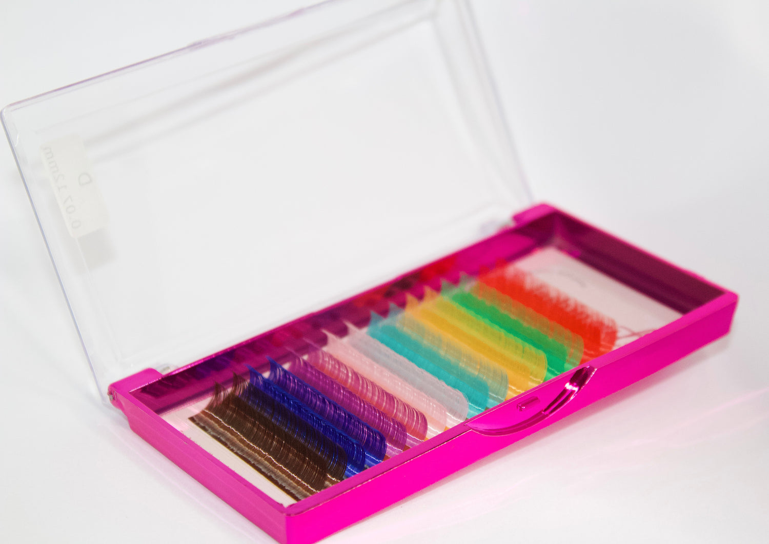 A tray of multicolored lashes. Front top to bottom: red, green, yellow, light blue, light pink, dark pink, dark blue, dark brown. 