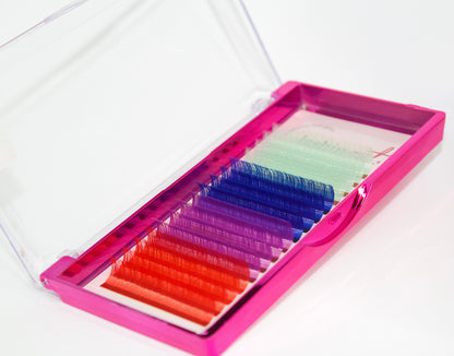 A tray of colored lashes. There are 4 rows of each color. From top to bottom the colors are: mint green, dark blue, purple and orange. 