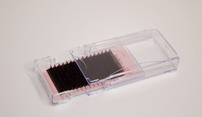 Clear tray with mixed length classic lashes. The drawer is half open and the strips of lashes are visible. 