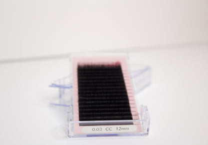 Front view of a tray of mixed length classic lashes. There is a label on the tray that says 0.03 CC 12mm. 