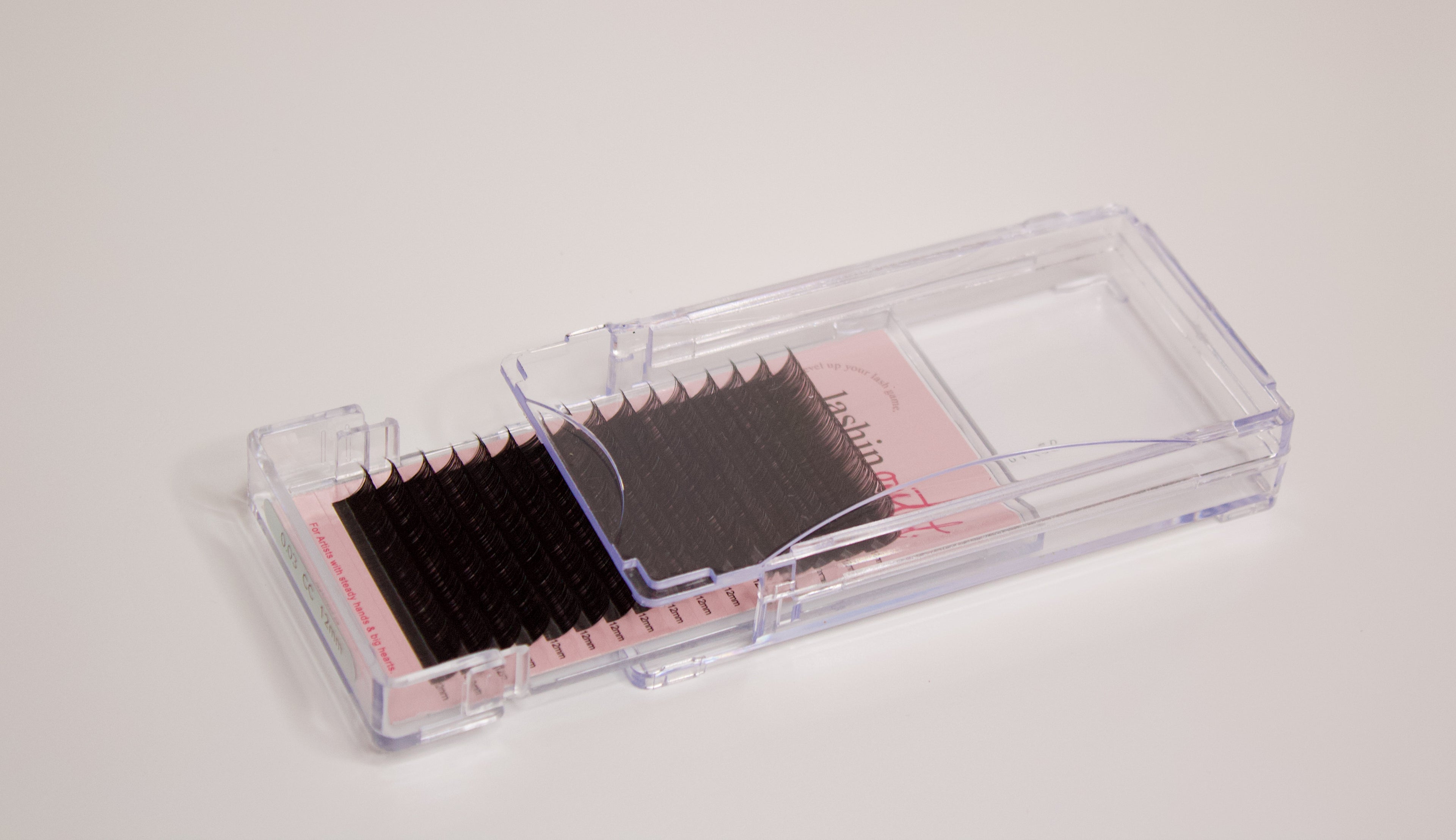 Clear tray with volume lash extensions inside. The drawer is half open and the rows of lashes are clearly seen on the sheet. 