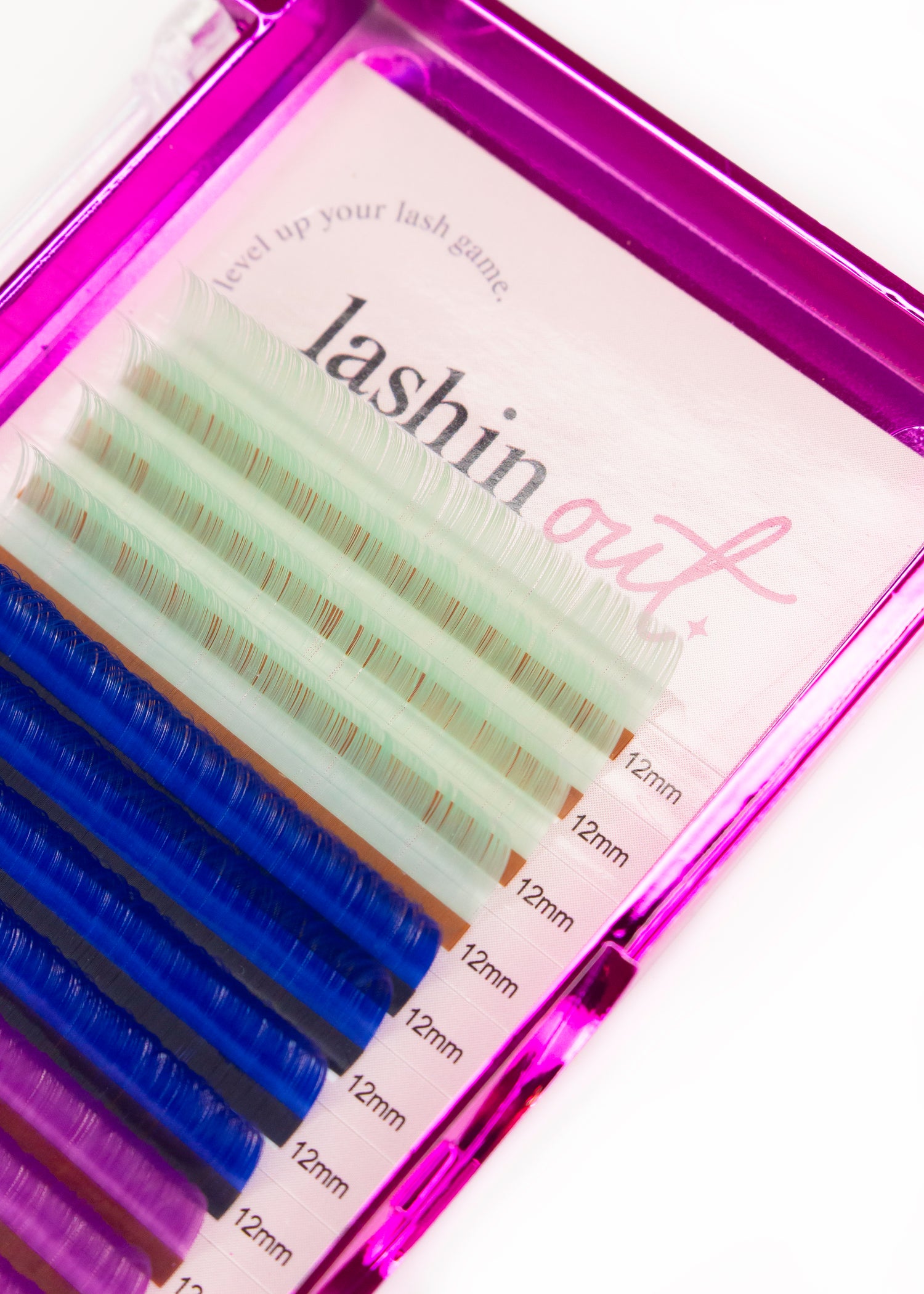 A tray of multicolored lashes. The colors are white, blue and pink. There are four lines of each color. They are 12 mm lashes. 