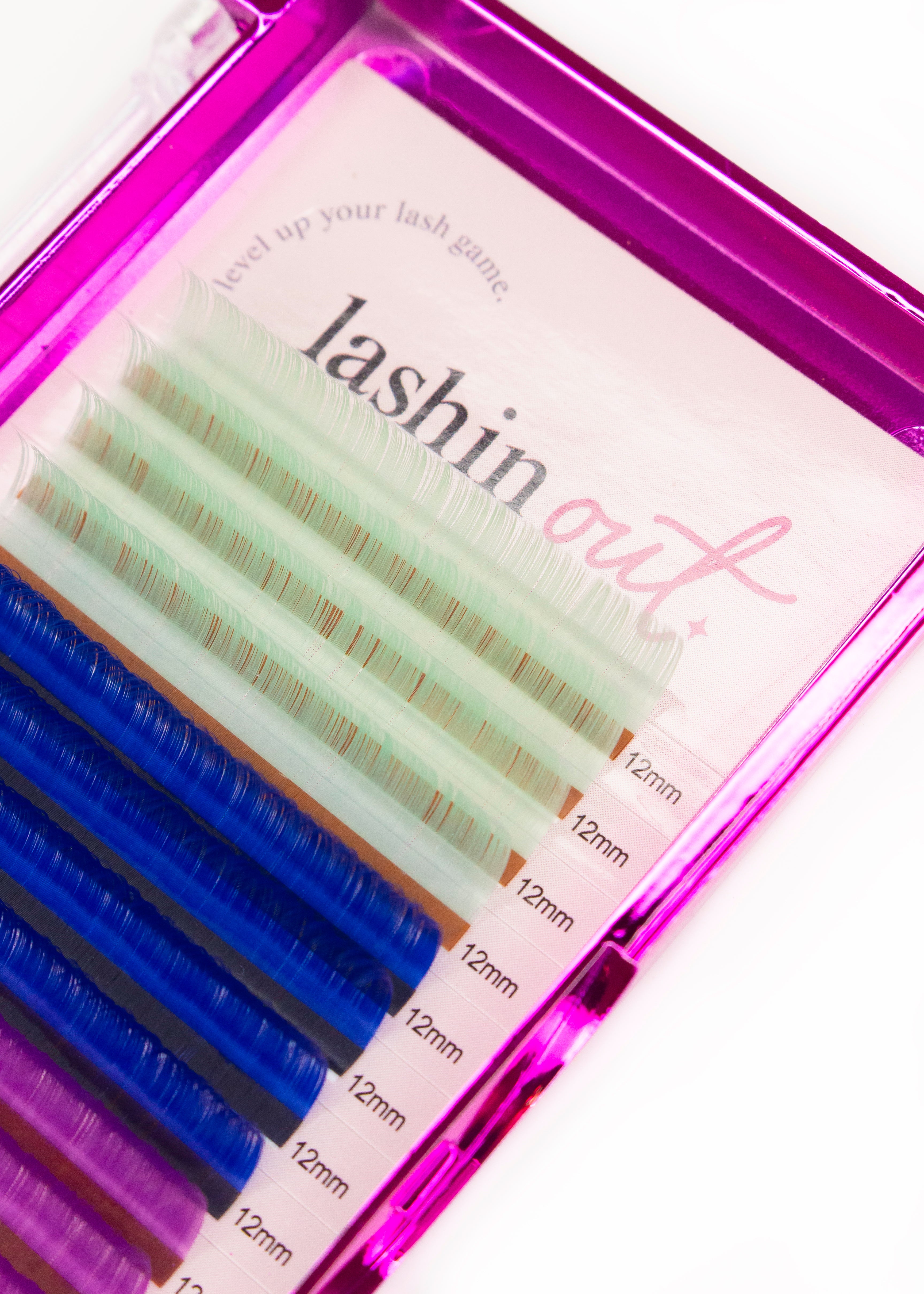 A tray of multicolored lashes. The colors are white, blue and pink. There are four lines of each color. They are 12 mm lashes. 