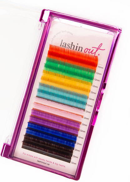 A tray of multicolored lashes. The colours are red, green, yellow, blue, pink, purple, dark blue and dark brown. There are two lines of each color. They are 12 mm lashes. 
