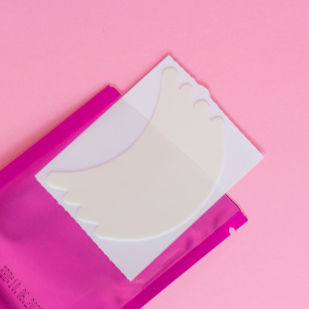 An opened package of flexi foam eye pads. The pads are pulled out of the package a quarter of the way. 