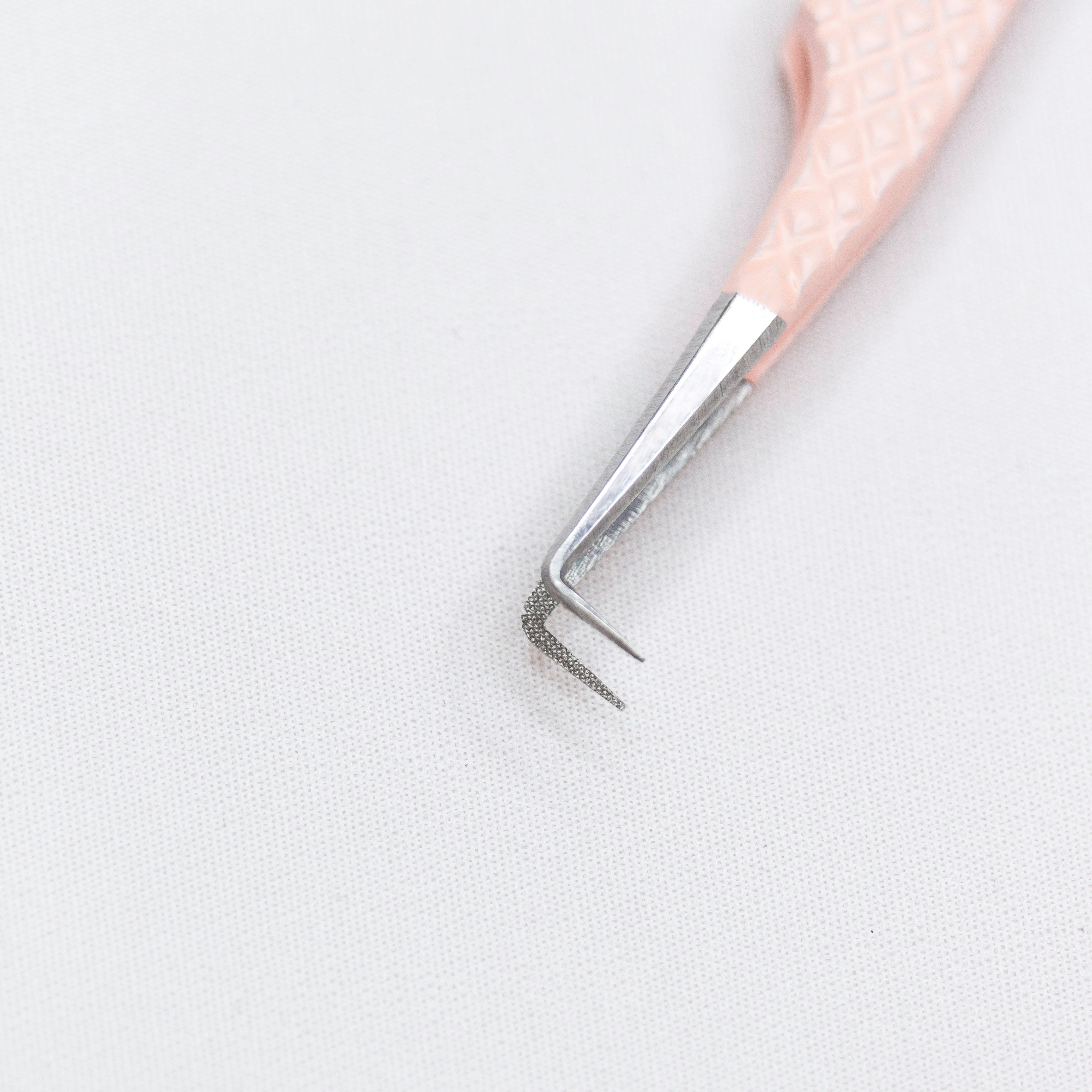 Close up of the tips of the Rosé 90º Blush Nano Tip Lash Tweezer. The tips are thin and at a 90 degree angle. 