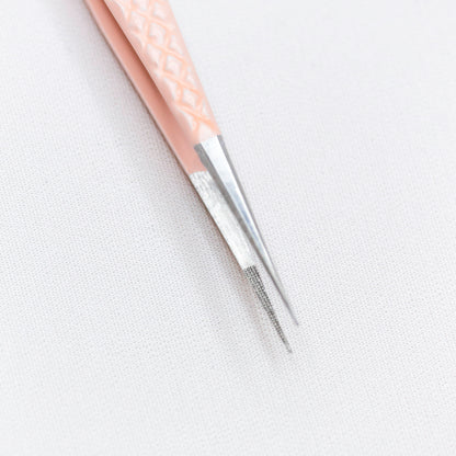 Close up view of the tips of the Slim Blush Nano Tip Lash Tweezer. 