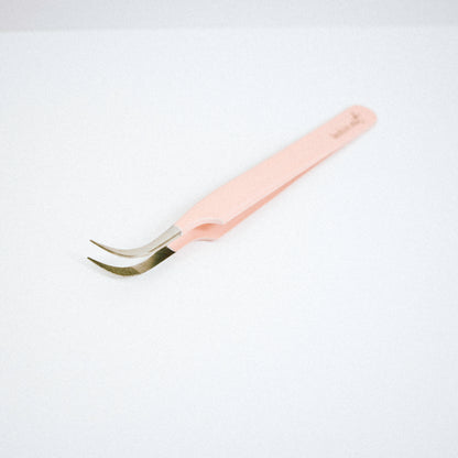 Top view of the Vetus Curved Blush Nano Tip Lash Tweezer. The tweezer is on the side with the curved tips facing upward. 