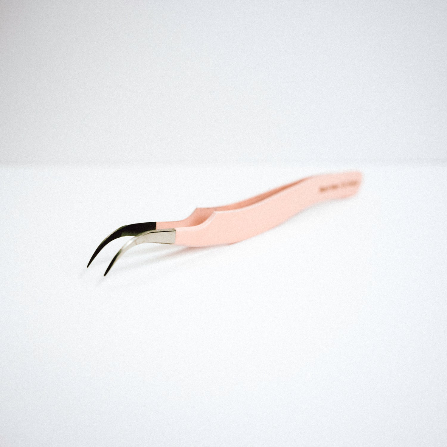 Front view of the Zaagi Curved Blush Nano Tip Lash Tweezer. The tips are curved downwards. 