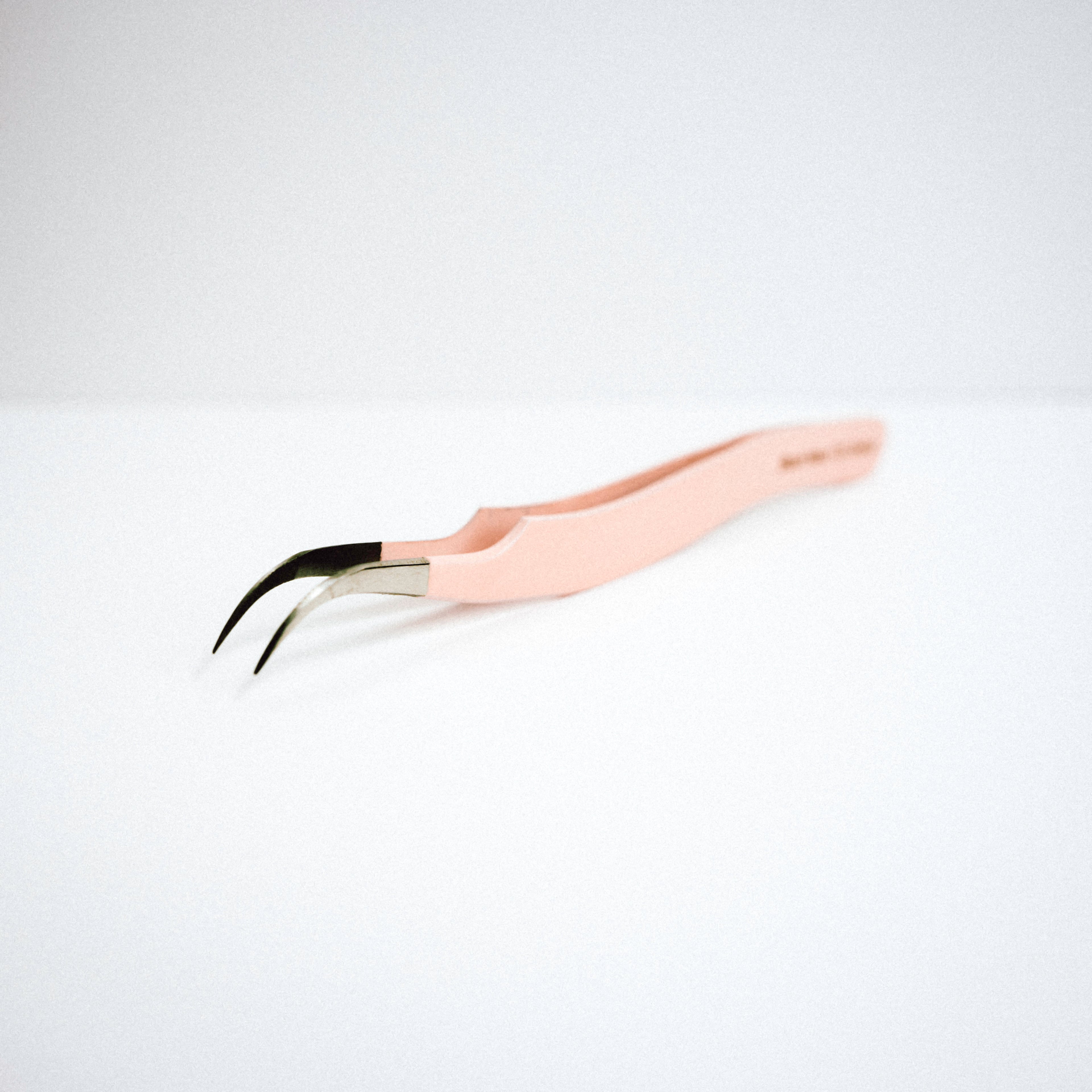Front view of the Zaagi Curved Blush Nano Tip Lash Tweezer. The tips are curved downwards. 